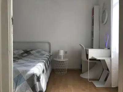 a white bedroom with a bed and a desk at Modern and Elegant Barcelona Apartment in Barcelona