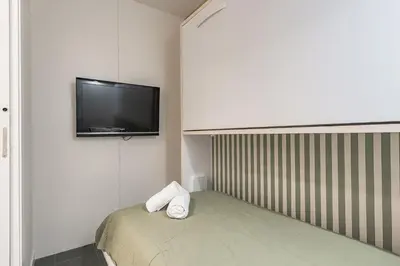 a small room with a bed and a flat screen tv at Sant Joan Design Apartment in Barcelona