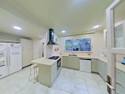 a large kitchen with white appliances and a window at Premium Habitat Les Villes in Arenys de Mar