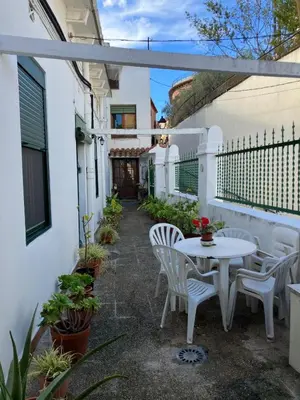 a white patio with a white table and chairs at Casa EMILIO in Olesa de Montserrat