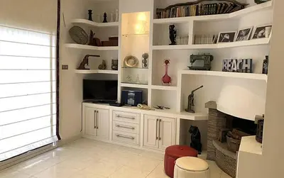 a living room with white shelves and a fireplace at Blanca Subur in Sitges