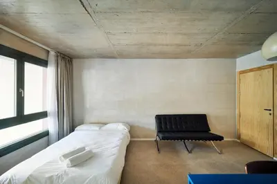a small room with a bed and a chair at Mooeve Montjuïc in Barcelona