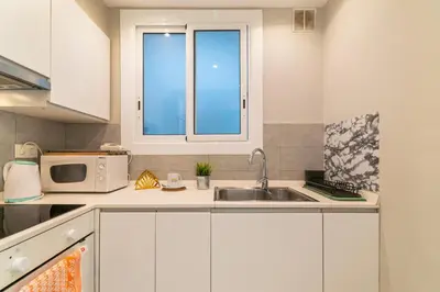 a kitchen with a sink and a microwave at Marblau Beach Vacation and Downtown Sitges in Sitges