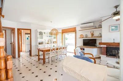 a kitchen and living room with a table and chairs at Can Montardo in Sant Pere de Ribes