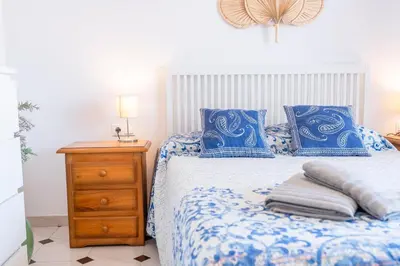 a bedroom with a blue and white bed with blue pillows at Can Montardo in Sant Pere de Ribes