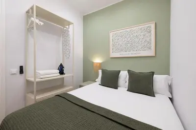 a bedroom with a large white bed and a mirror at Stay U-nique Apartment Passeig d´Amunt in Barcelona