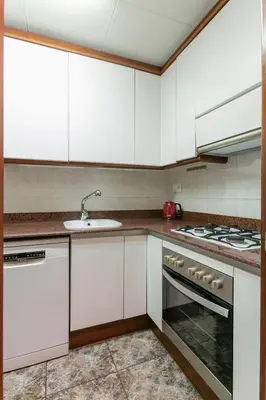 a kitchen with white cabinets and a sink at Centric Apartment with Balcony in Barcelona