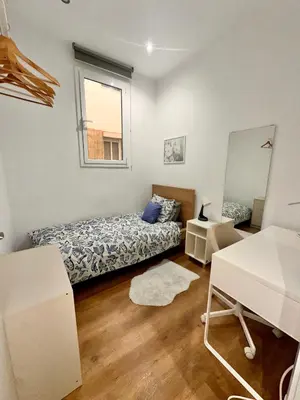 a small bedroom with a bed and a tv at Habitación 2 Ronda Sant Pau in Barcelona