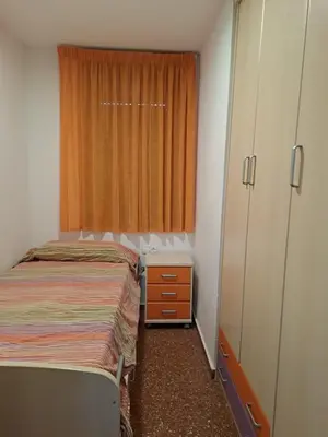 a small bedroom with a bed and a window at Voramar, Apartamento a primera línea de mar y con piscina in Canet de Mar