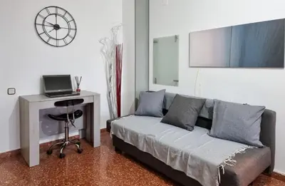 a living room with a couch and a desk with a laptop at Voramar, Apartamento a primera línea de mar y con piscina in Canet de Mar