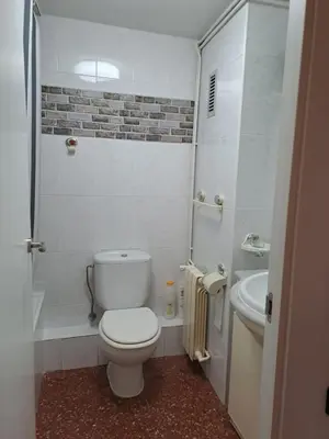 a white bathroom with a toilet and a sink at Voramar, Apartamento a primera línea de mar y con piscina in Canet de Mar