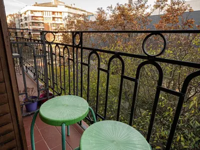 a balcony with two green tables and a fence at Apartment amazing Sagrada familia view I in Barcelona