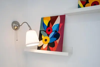 a shelf with a painting of a flower on it at Apartamento Completo junto playa y Centro Bcn in Badalona