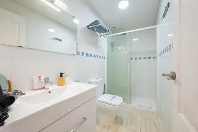 a bathroom with a toilet and a glass shower at Apartamento Completo junto playa y Centro Bcn in Badalona