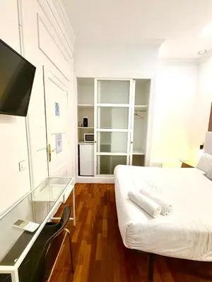 a living room with a white bed and a tv at Hotelito Luxe in Barcelona
