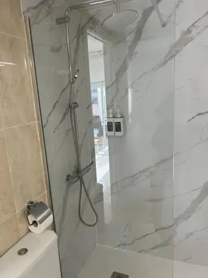 a bathroom with a shower with a glass door at Apartamentos ELMA1 in Castelldefels