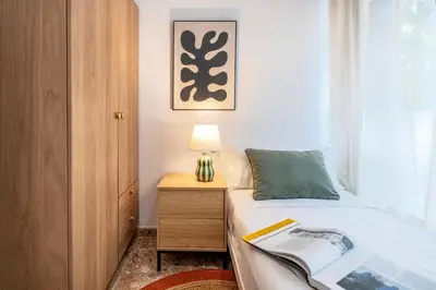 a bedroom with a bed and a table with a lamp at Charming 3-Bedroom Flat in the Heart of Les Corts in Barcelona