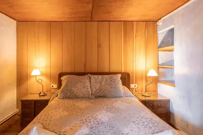 a bedroom with a bed with two nightstands and two lamps at Masia Brugarolas in Castelltersol