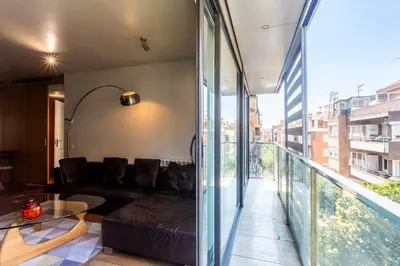 a living room with a couch and a glass balcony at Apartment Barcelona Rentals - 3 bedroom penthouse with large terrace in Barcelona