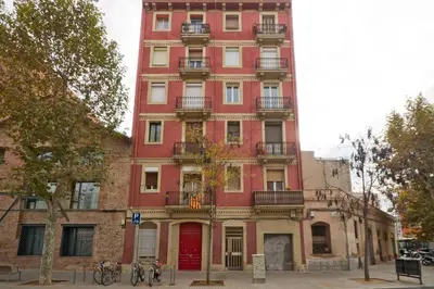 a tall red building with balconies on a street at Apartment Poble Nou in Barcelona