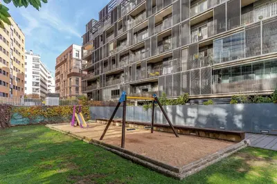 an empty playground in front of a building at Canela Homes BARCELONA POBLENOU in Barcelona