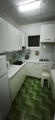 a kitchen with white cabinets and a green floor at Playa de Sant Adrià de Besòs in Sant Adria de Besos