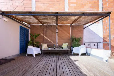a patio with a table and chairs on a wooden deck at Barcelona - Loft Paseo de gracia in Barcelona