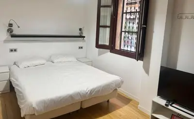 a white bedroom with a bed and a television at Barceloneta Beach 2 in Barcelona