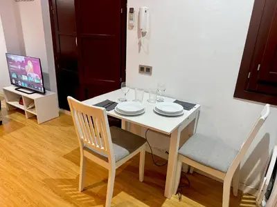 a dining room table with two chairs and a white table with glasses at Barceloneta Beach 2 in Barcelona