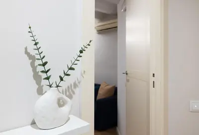 a white vase sitting on a table with a plant in it at Stay U-nique Sant Pau in Barcelona