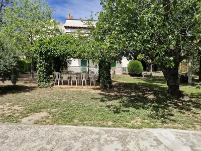 a yard with a table and chairs and trees at Cal Llanto in Torrellas de Foix
