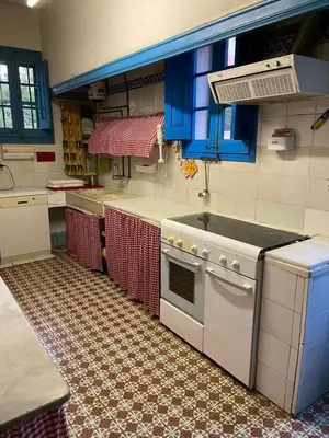 a kitchen with a white stove and blue cabinets at Cal Llanto in Torrellas de Foix