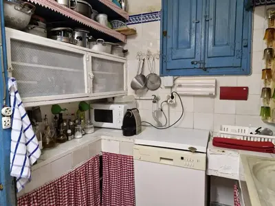 a small kitchen with blue cabinets and a microwave at Cal Llanto in Torrellas de Foix