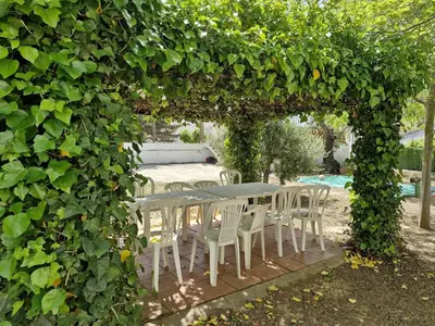 a table and chairs under an arch covered in ivy at Cal Llanto in Torrellas de Foix