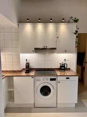 a kitchen with white cabinets and a washing machine at Cozy Barceloneta Beach Flat - Newly Renovated in Barcelona