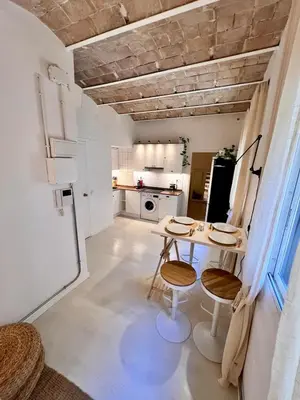 a kitchen with a table and chairs in a room at Cozy Barceloneta Beach Flat - Newly Renovated in Barcelona