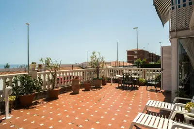 a patio with benches and tables on a balcony at Best sea views, 20 minutes to Barcelona in Montgat