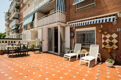 a patio with chairs and tables and a building at Best sea views, 20 minutes to Barcelona in Montgat