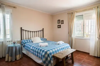 a bedroom with a bed with a blue and white blanket at Best sea views, 20 minutes to Barcelona in Montgat