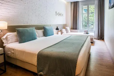a hotel room with a large bed with blue pillows at Hotel Well and Come Barcelona in Barcelona