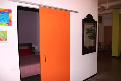 an orange door in a room with a bed at Loft Sant Martí - Glories in Barcelona