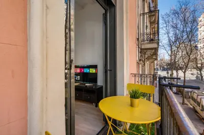 a kitchen with white cabinets and a stainless steel refrigerator at Stylish Apartment with Balcony in Central Barcelona in Barcelona