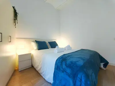 a bedroom with a large white bed with blue sheets at Apartamento turístico Muntaner Bonanova Sarrià in Barcelona