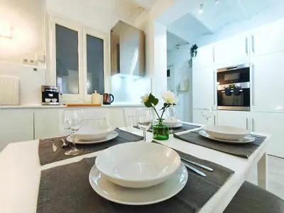 a kitchen with a table with plates and wine glasses at Apartamento turístico Muntaner Bonanova Sarrià in Barcelona