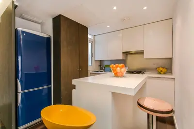 a kitchen with a blue refrigerator and a yellow stool at Design Apartment in Barcelona in Barcelona