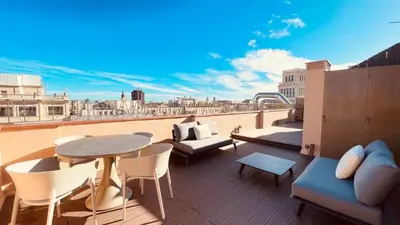 a balcony with a table and chairs on a roof at Ático premium Rambla Catalunya - Terraza 50 m2 in Barcelona