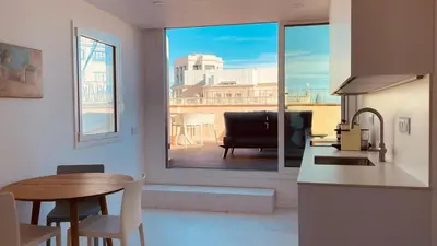 a kitchen with a table and a window with a view at Ático premium Rambla Catalunya - Terraza 50 m2 in Barcelona