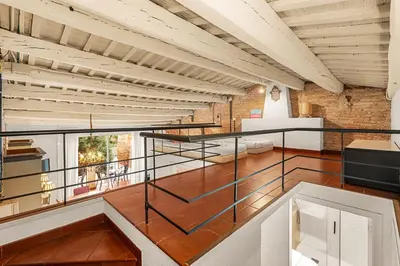 a large room with a staircase and a brick wall at Gràcia Loft Terrace BBQ AC & Fiber Wi-Fi in Barcelona