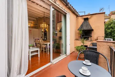 a patio with a table and chairs on a balcony at Gràcia Loft Terrace BBQ AC & Fiber Wi-Fi in Barcelona