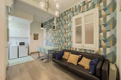a living room with a couch and a table and a kitchen at Central apartment in Barcelona in Barcelona